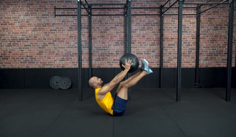 Untere Bauchmuskeln trainieren: Beinheben mit Medizinball