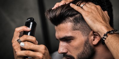 Mann verwendet Trockenshampoo – schnelle Haarpflege für Volumen und Frische zwischen den Wäschen